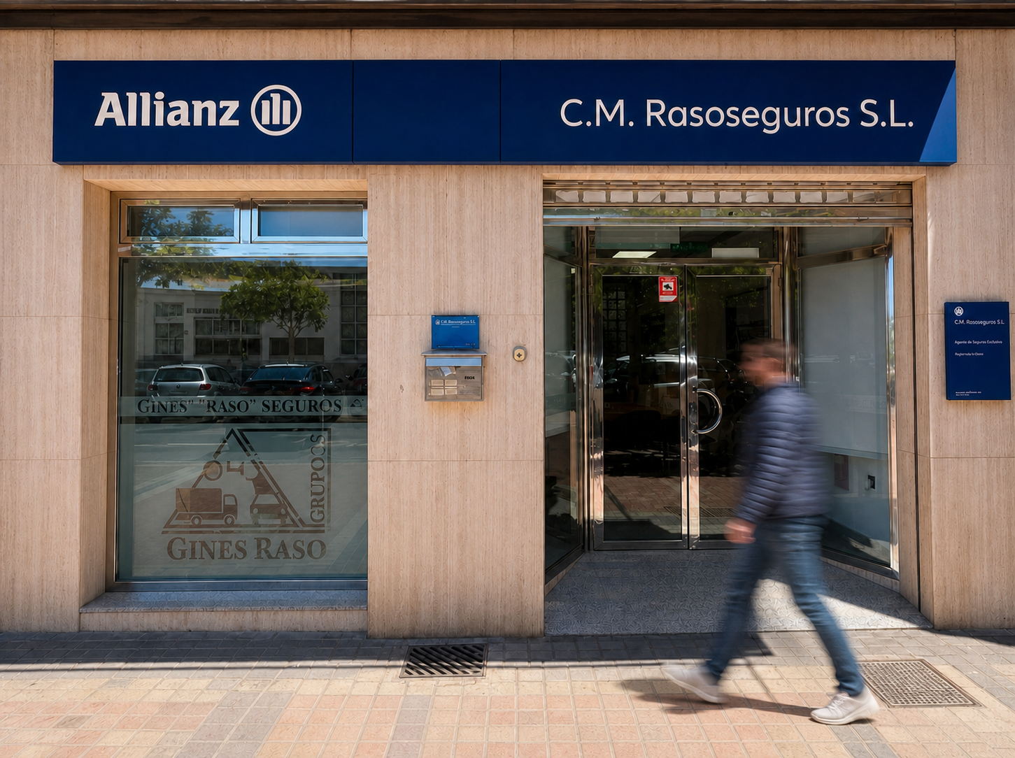 Fachada de la oficina de Raso Seguros en Águilas con una persona pasando frente a la entrada
